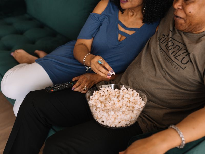 An older couple watching a movie together